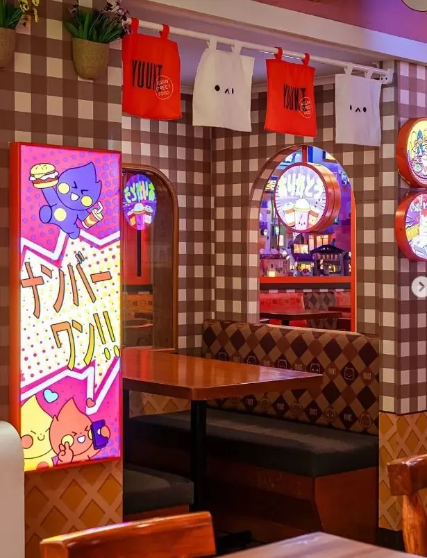 Una cabina con un cartel de cómic iluminado y bolsas de tela colgadas en la pared.