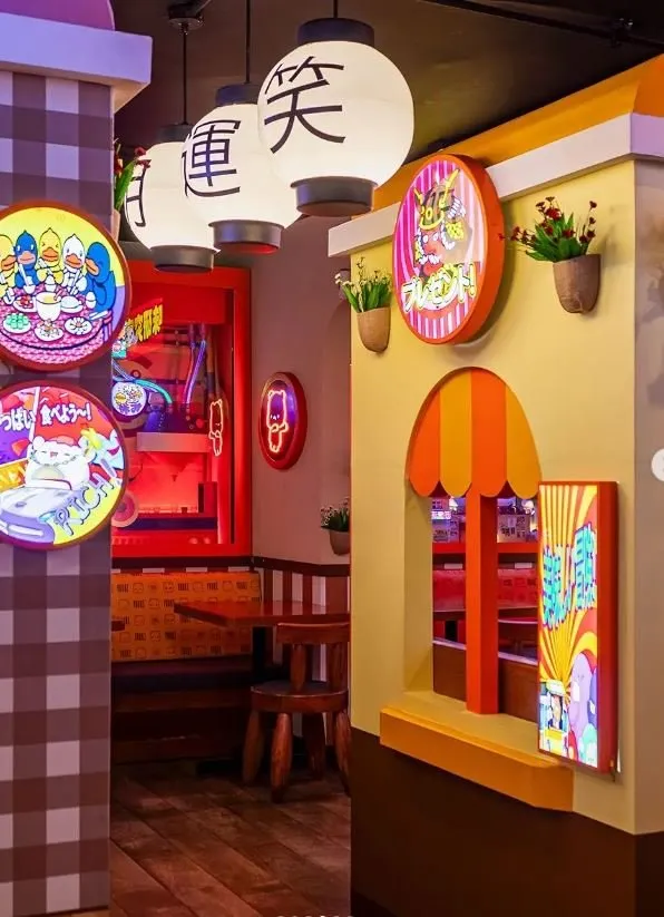 Un farol con caracteres japoneses y una ventana en arco con toldo naranja.